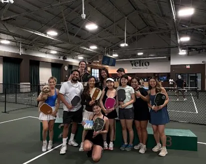 Tournament group photo with trophies on court at Velto